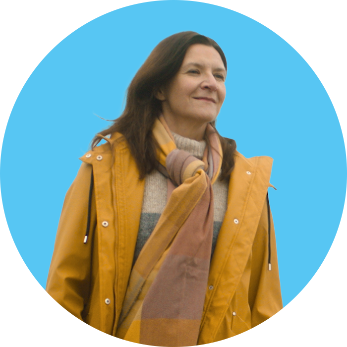 woman smiling and looking into the distance with blue background