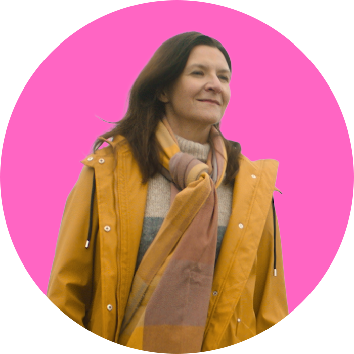 woman smiling and looking into the distance with pink background