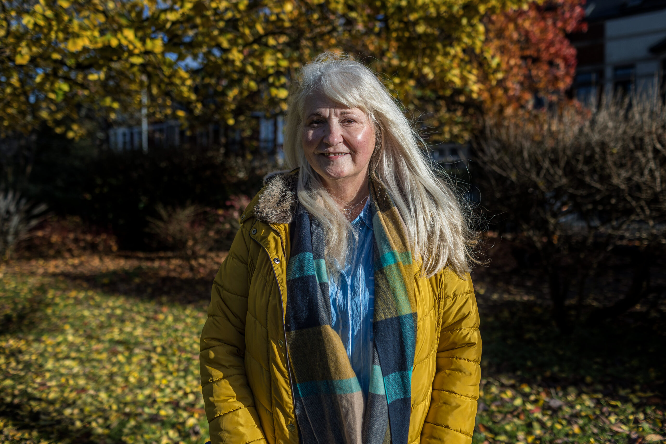 Portrait of a woman smiling outside with trees behind her